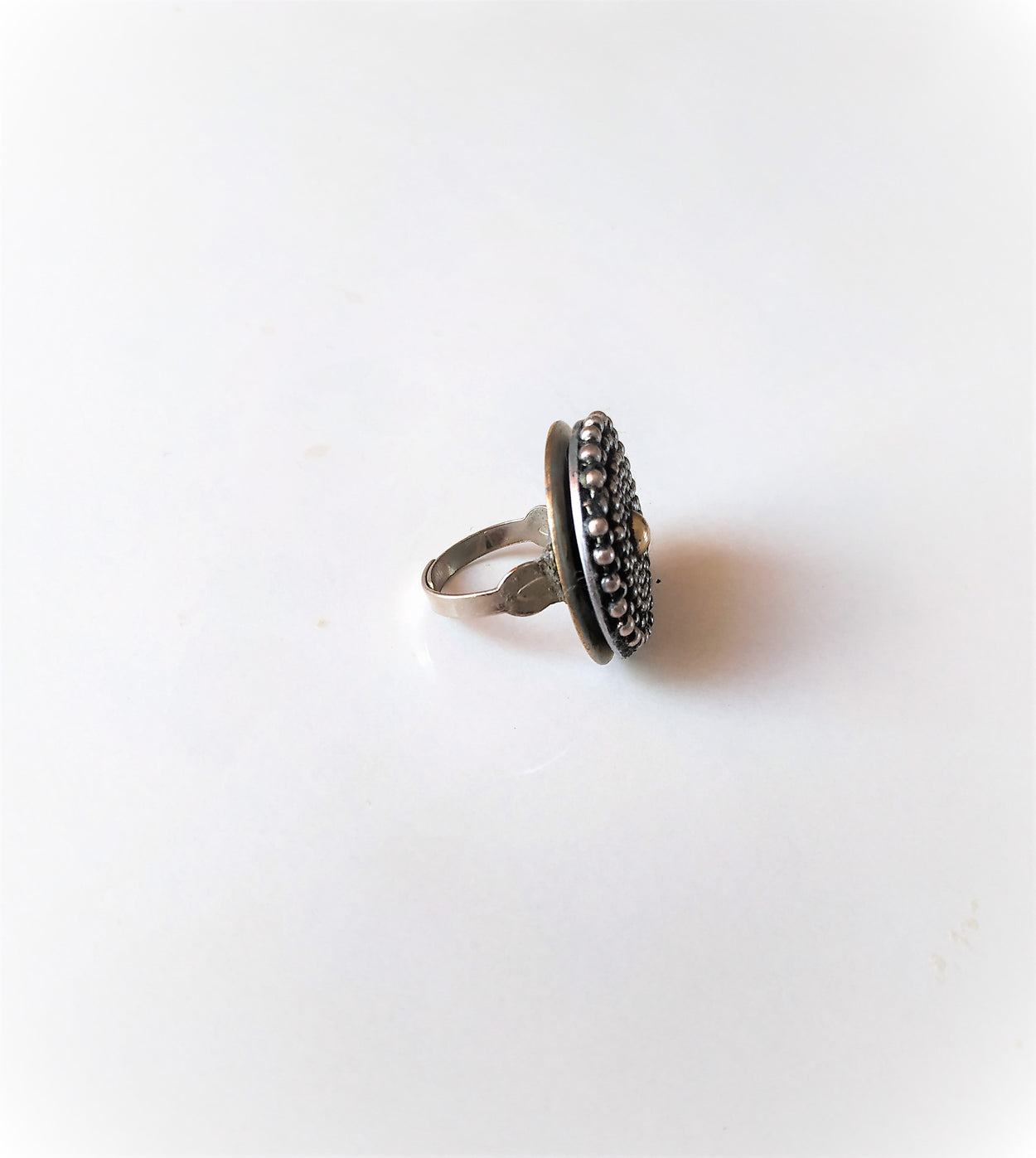 Unique white metal ring with a yellow metal ball in the center