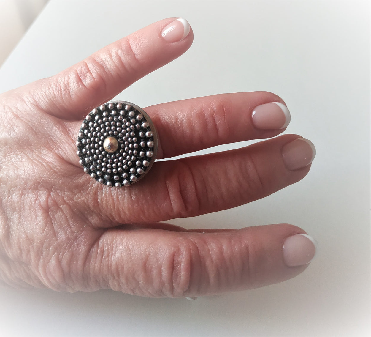 Unique white metal ring with a yellow metal ball in the center