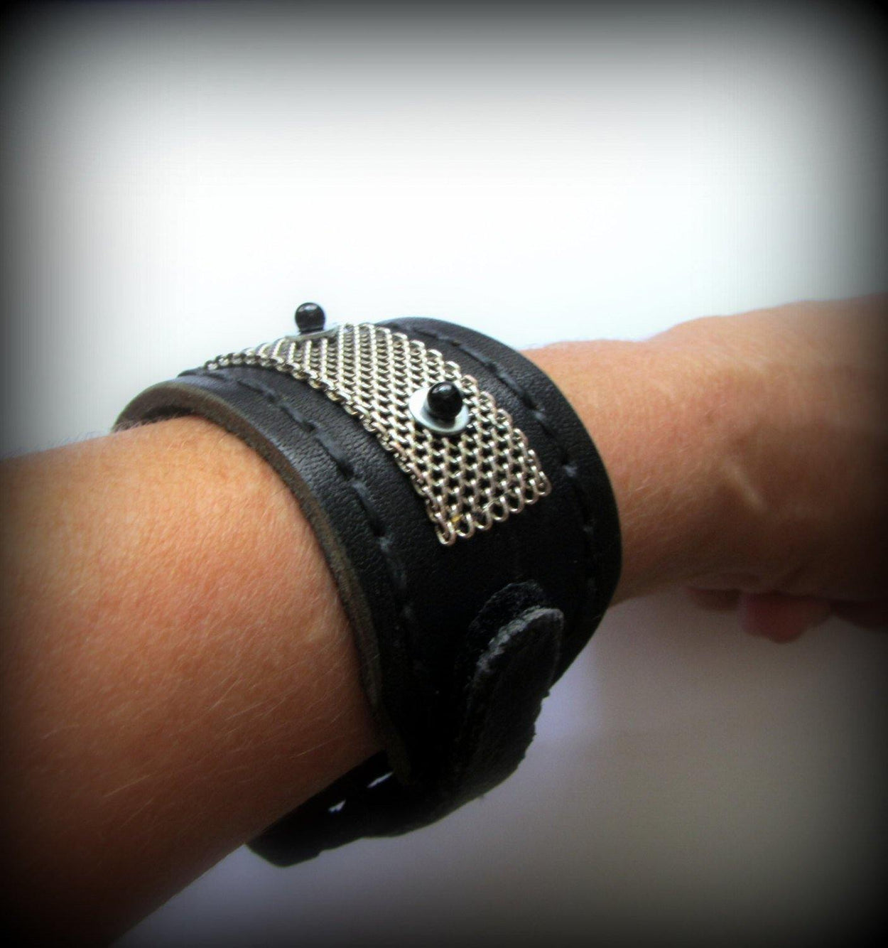 Black leather bracelet decorated with chainmail and white metallic disc with black stone beads on them. Closure - strap with velcro. - GLEZANT designer goods store.