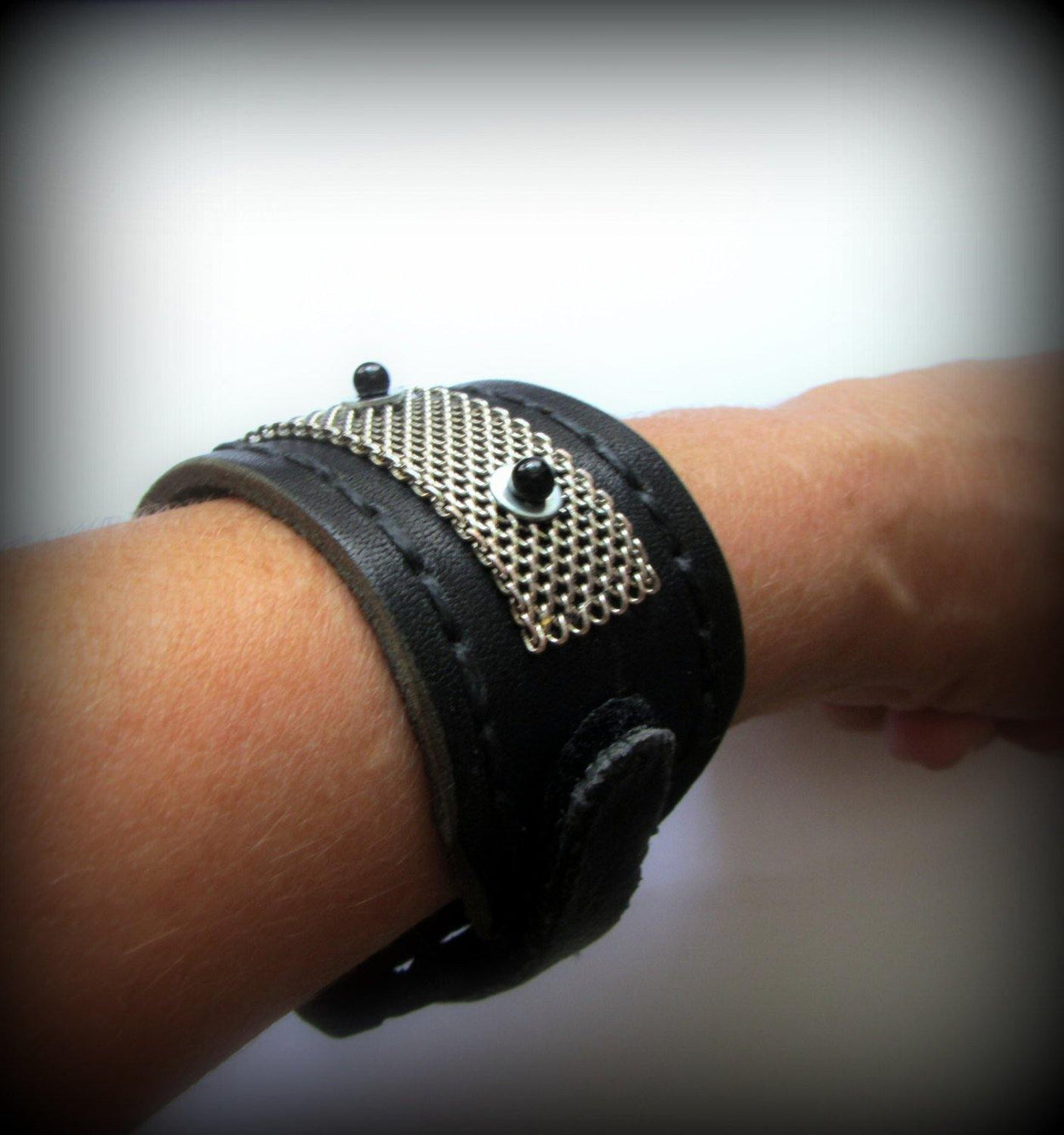 Black leather bracelet decorated with chainmail and white metallic disc with black stone beads on them. Closure - strap with velcro. - GLEZANT designer goods store. 